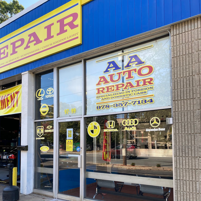 Front entrance window with AA Auto Repair logo and contact information
